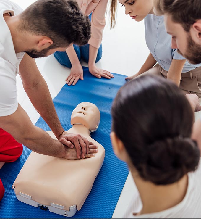 man-demonstrating-cpr-on-dummy-for-students